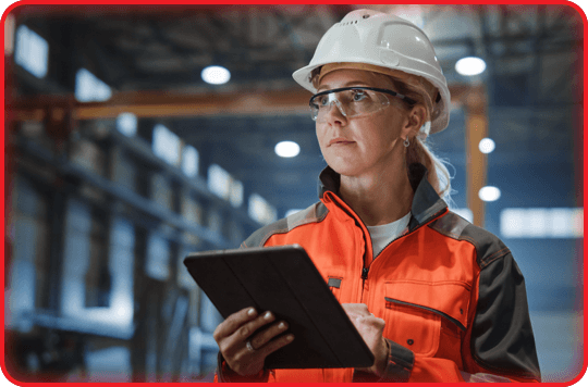 Female factory employee holding clipboard and wearing PPE