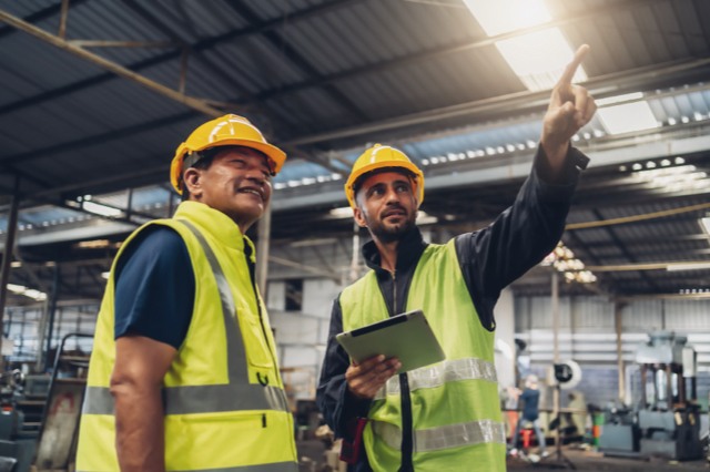 two machine safety installers wearing safety vests
